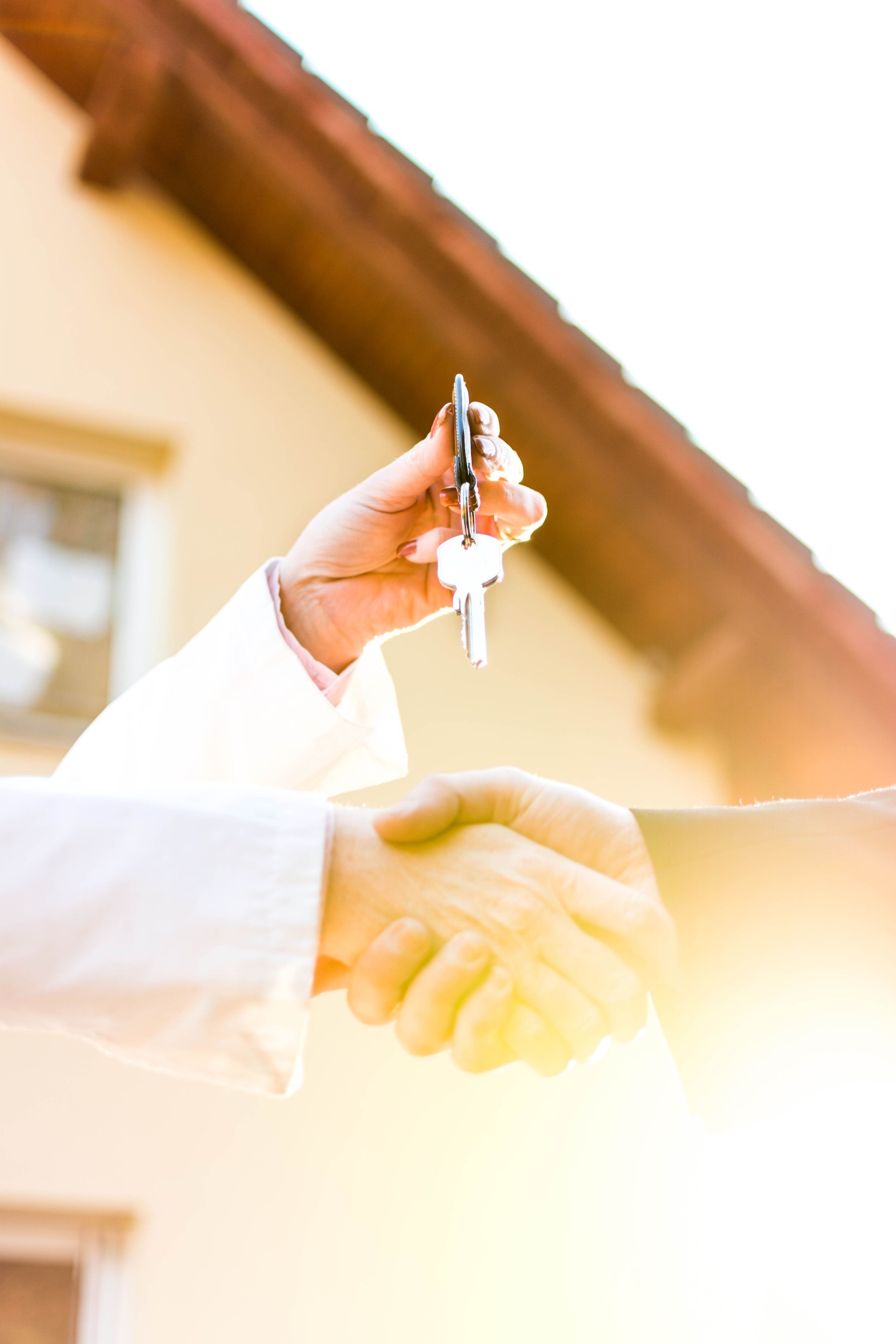 Handing  keys in front of house